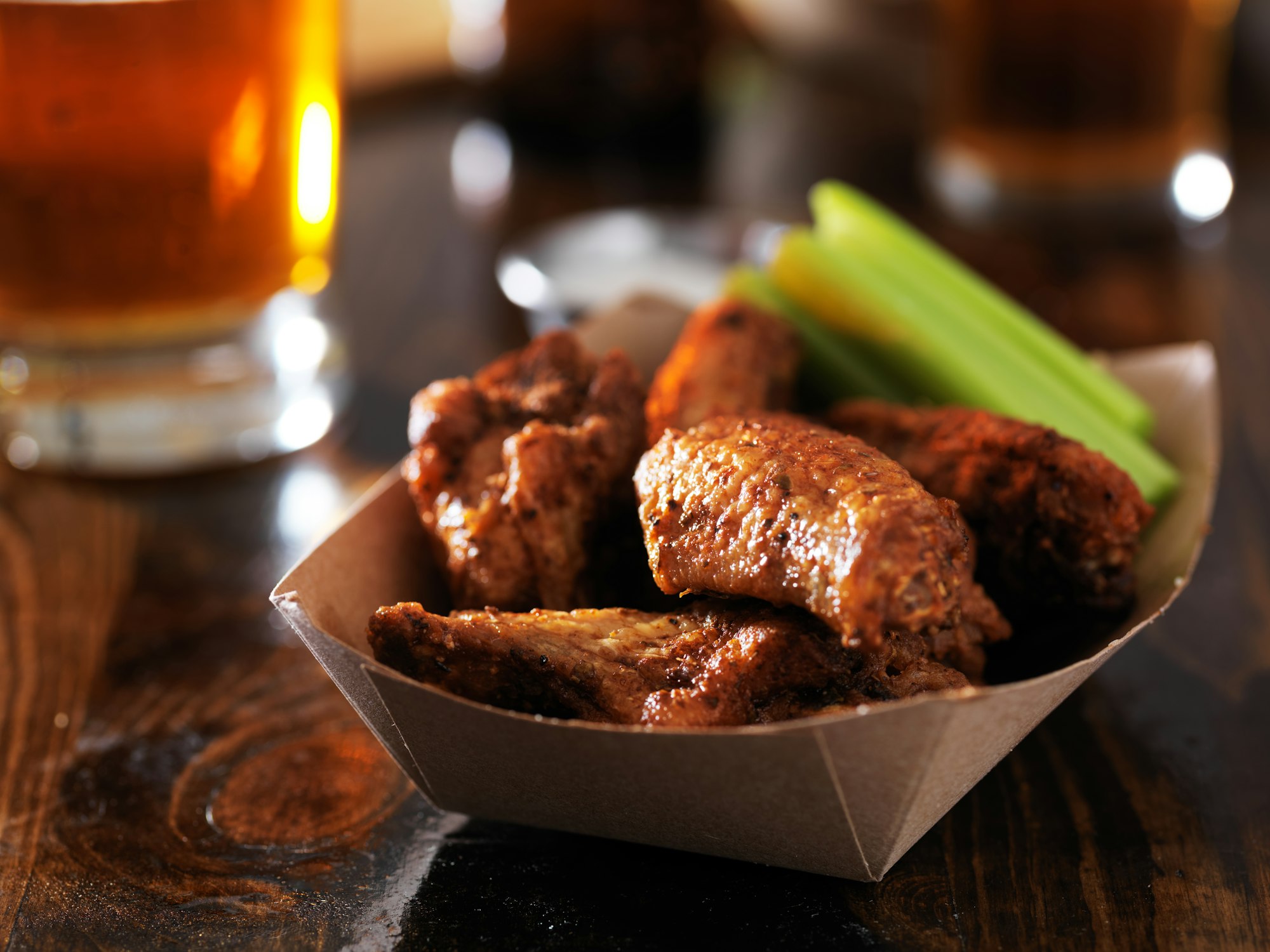 barbecue chicken wings with celery in basket on restaurant table